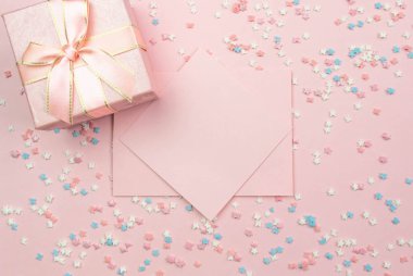 Kayıt düzeni. Yazmak için pembe levha ve yıldız ve yay ile dekoratif çok renkli unsurları ile pembe bir arka plan üzerinde bir hediye kutusu. Düz döşeme, üst görünüm