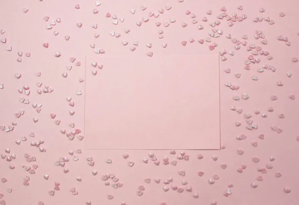 Pink sheet for writing on a pink background and decorative hearts. Marriage proposal concept, Valentines Day, International Womens Day. Flat lay, top view