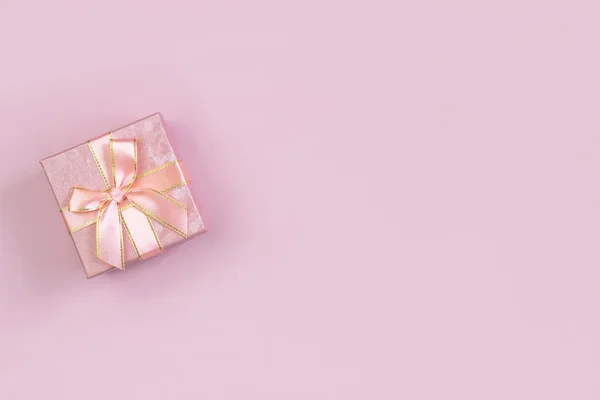 Rosa Geschenkschachtel auf rosa Hintergrund mit Platz zum Schreiben. Layout für die Aufnahme. flache Lage, Draufsicht — Stockfoto