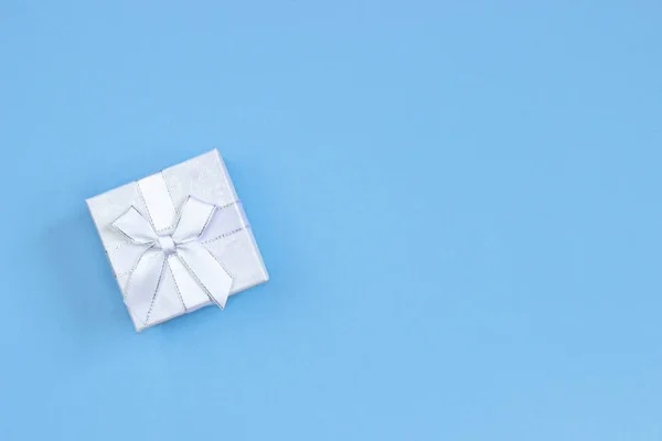 Rosa Geschenkbox auf blauem Hintergrund mit Platz zum Schreiben. Layout für die Aufnahme. flache Lage, Draufsicht — Stockfoto