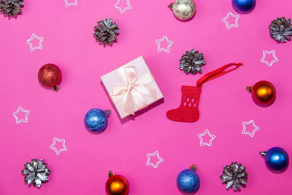 New Year decorations on a bright pink background. Gift box, Christmas cones and stars on a Christmas background. — Stock Photo, Image