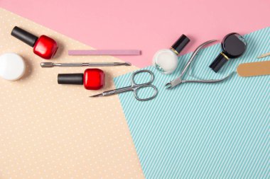 Pembe ve mavi arka planda manikür için araçlar. Tırnak törpüleri, makas ve tırnak cilası üst görüntü. Manikür Salonu, Güzellik Salonu.