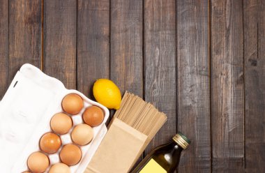 Yemek pişirmek. Tahta bir masada yumurta, makarna ve zeytinyağı..