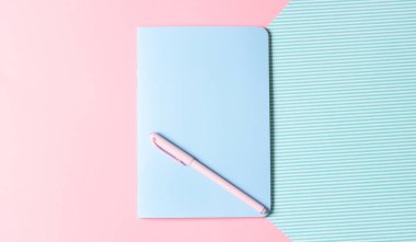 Düz yerde kadın işyeri vardı. Pembe arka plandaki defter ve kalem. Blogların ve sosyal ağların tasarımı.