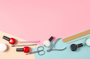 Pembe ve mavi arka planda manikür için araçlar. Tırnak törpüleri, makas ve tırnak cilası üst görüntü. Manikür Salonu, Güzellik Salonu