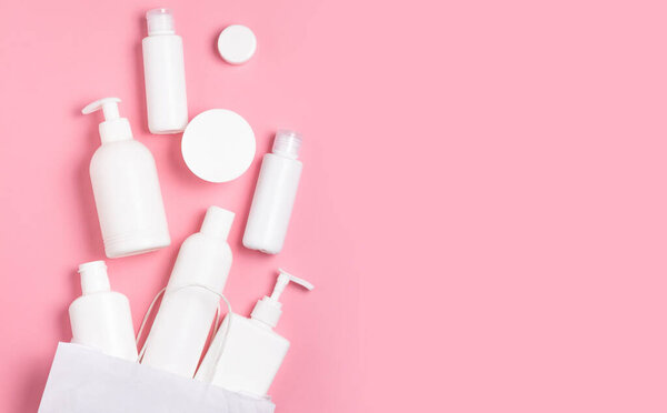 Белые косметические банки на розовом фоне. Косметика для ухода за кожей.