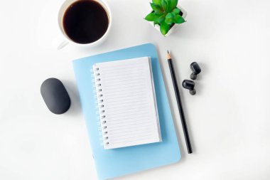 Beyaz bir masa üzerinde açık defter ve kalemle kadın çalışma alanı. Evden çalışmak, blogcu işyeri.