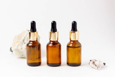 Gerekli yağlar ve kozmetik ürünler için Amber Şişe. Beyaz arka planda cam şişe. Bir damlatıcı, spreyli bir şişe.