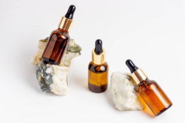 Gerekli yağlar ve kozmetik ürünler için Amber Şişe. Beyaz arka planda cam şişe. Bir damlatıcı, spreyli bir şişe.