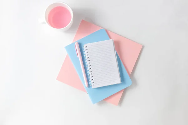 Female workspace with empty open notebook for writing, pen on a white table. Top view, flat lay, copy space, minimalism.