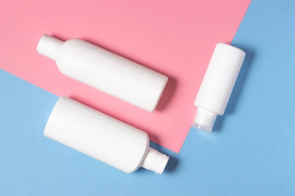 Kozmetikai fehér palackok feküdnek fényes háttérrel. Arc- és testápolási eszközök otthon és szépségszalonban. — Stock Fotó
