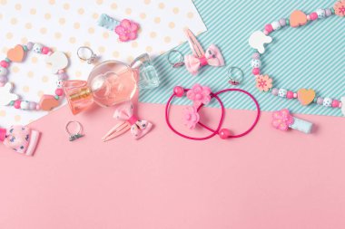Çocuk yatağı. Şeker şeklinde parfüm, pembe arka planda çocuk mücevherleri ve saç aksesuarları. Küçük kızlar için aksesuarlar.