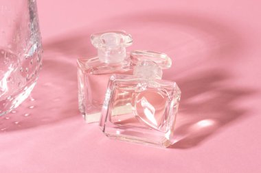 Sert gölgeli parlak güneş ışığında cam parfüm şişeleri..