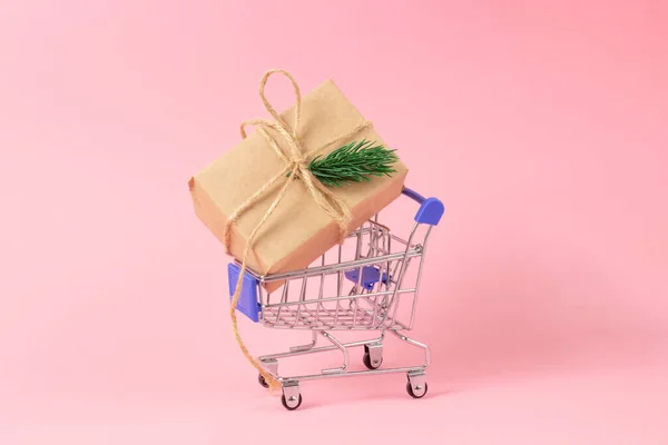 Caja de regalo envuelta en papel kraft en una cesta de la compra. Concepto de compra de regalos, tienda online —  Fotos de Stock