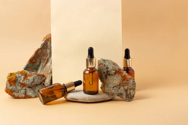 An amber bottle for essential oils and cosmetics stands next to the stone. Glass bottle. Dropper, spray bottle. Natural cosmetics concept.