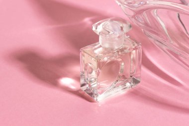 Sert gölgeli parlak güneş ışığında cam parfüm şişeleri..