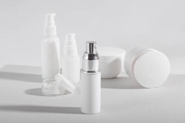 Beyaz kozmetik şişeler ve sert gölgeli kavanozlar. Ev ve güzellik salonu konsepti