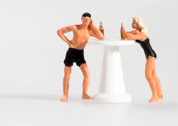 迷你男人和女人喝在一个亭站在游泳服装上靠在桌子上聊天与复制空间的白色 — 图库照片