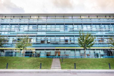 Büyük modern ticari ofis cam pencere ve ağaçlar ön planda Bina dış.