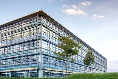 Büyük yüksek doğmak modern ofis ön planda ağaçlarıyla Binası.