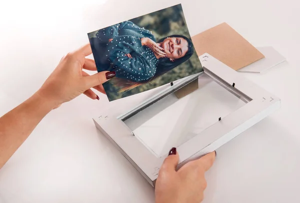 妇女放置在一个简单的白色木框架一个微笑的女士的彩色照片在她的手特写视图 — 图库照片