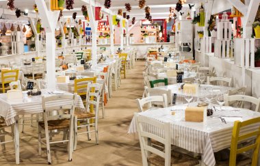 İçinde belgili tanımlık çarşı ile hizmet ve ayrılmış, beyaz kare masa ve renkli tavan süslemeleri boş Restoran