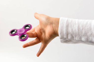 Mor spinner oyuncak çocuklar parmağında döndürüyor. El Beyaz arka plan üzerinde Kapat'görüntülendi?