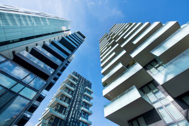 Açık güneşli mavi gökyüzü karşı büyük balkonlu modern Milan gökdelenlerin düşük açılı yakınsak perspektif