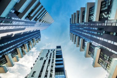Aşağıdan bir mavi gökyüzü karşı yakınsama gibi ararken büyük balkonlu modern Milan apartman blokları düşük perspektif görünümü