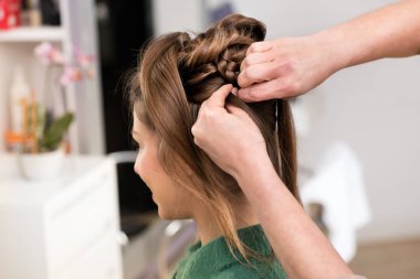 Yakın çekim yan görüntülendi güzellik salonda esmer kız için yaratıcı bir saç kesimi penye sırasında profesyonel salonların eller