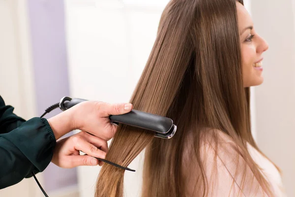 Hairstylist Using Flat Iron Long Brown Hair Attractive Young Woman — Stock Photo, Image