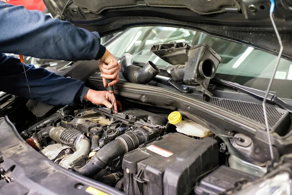 Meccanico di lavoro su un motore di auto che fa le riparazioni — Foto Stock