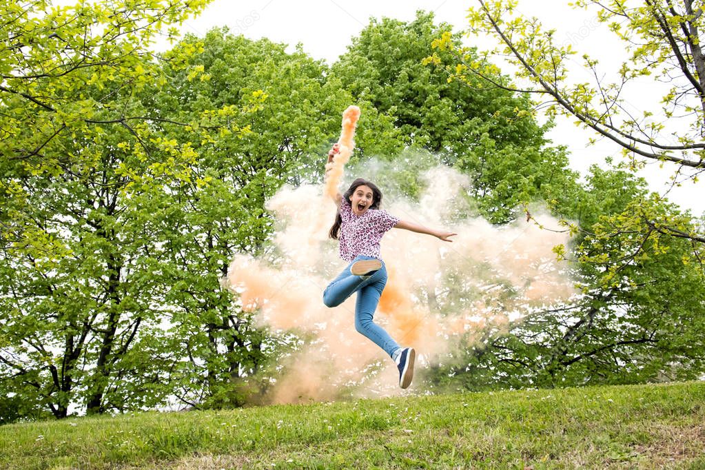 Agile excited girl with a colored smoke flare