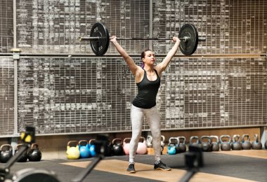 Spor salonunda kapan atletik bir kadın.