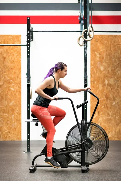 Fit young woman working out on an exercise bike