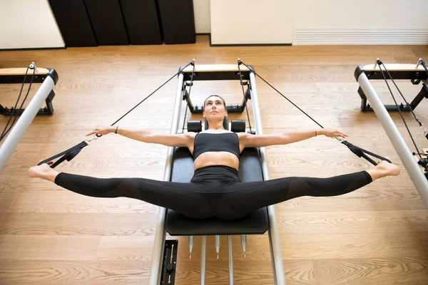 Bacaklar streç Pilates makinesi kullanarak yetişkin — Stok fotoğraf