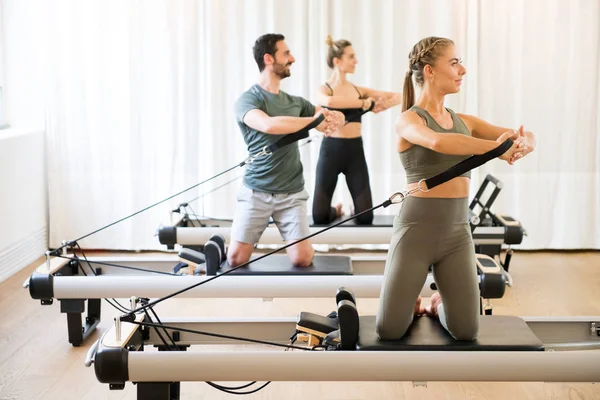 Tre persone che esercitano la rotazione torson in palestra — Foto Stock