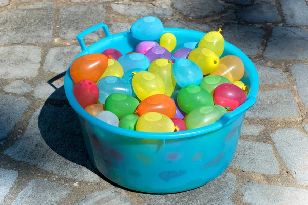 Blue plastic tub filled with water bombs — Stock Photo, Image