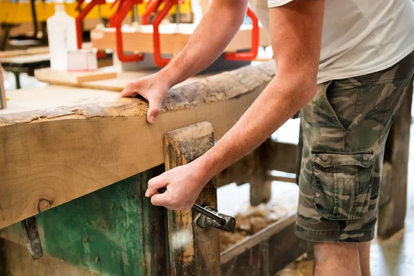 Timmerman aanscherping van een houten plank in een bankschroef — Stockfoto