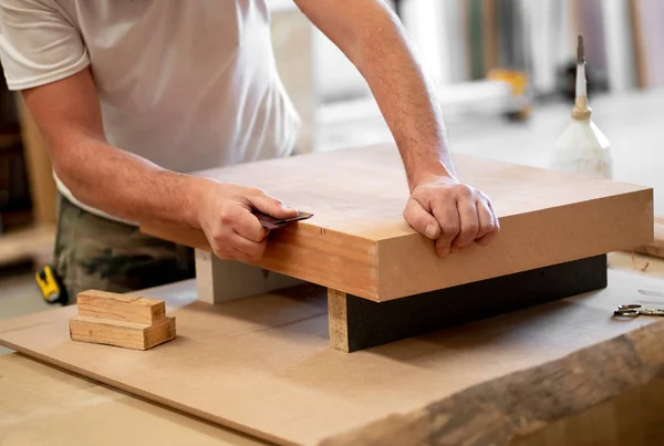 Stolarz szlifuje krawędź drewnianego bloku — Zdjęcie stockowe