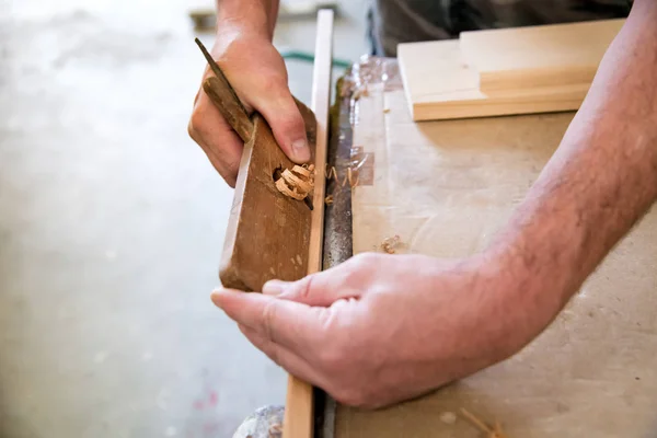 Tischler mit Hobelmaschine auf einem Holzbrett — Stockfoto