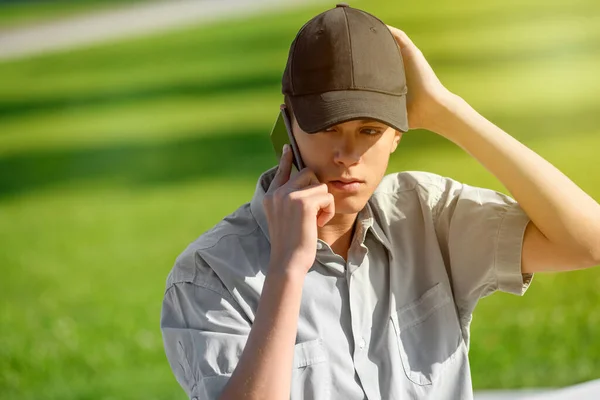 Junger Teenager Mit Schirmmütze Steht Draußen Vor Grünem Gras Und — Stockfoto