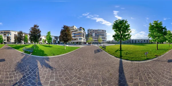 Çimenli yeşil çimenleri ve güneşli mavi gökyüzünün altında asfalt kaldırımları olan modern, temiz konutlarda 360 panorama manzaralı evler.