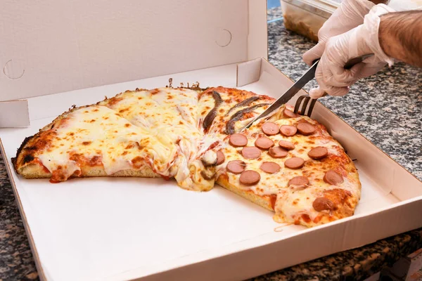 Chef Com Mãos Enluvadas Cortando Uma Pizza Com Coberturas Variadas — Fotografia de Stock