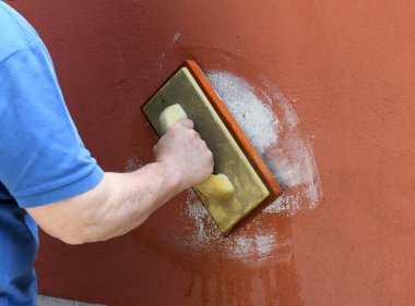 Tuğlacı, bakım, inşaat ya da yenileme konseptine harcı uygularken duvarın duvarını boyayarak duvarın rengini yakınlaştırıyor.