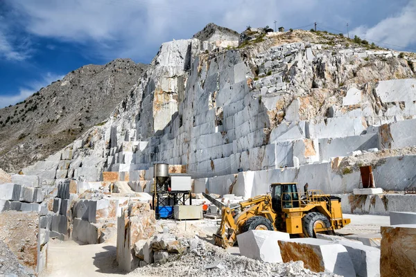 Industrial machinery in an open cast marble quarry mining white Carrara marble in northern Tuscany, Italy