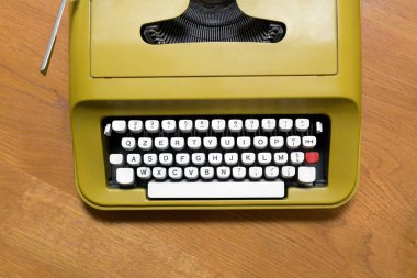 Eski bir retro daktilonun alfanumerik klavyesinde tepeden aşağı görünüm bir iletişim ya da iş konseptinde ahşap bir masanın üzerinde