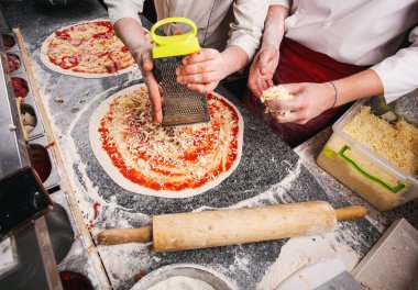Peynir pizza için ekleme. Pizza pişirme aşamaları.
