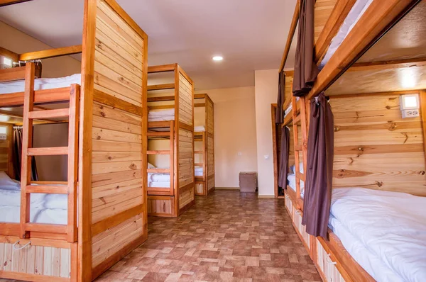 Bunk wooden beds in the hostel. Personal lighting over each bed.