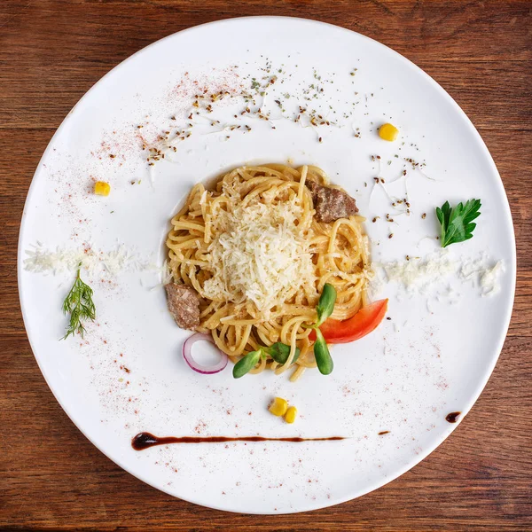 Pasta con queso parmesano y trozos de carne en el plato — Foto de Stock